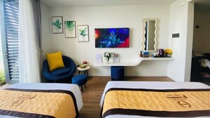 Habitación de hotel con dos camas, televisor, escritorio y una silla.