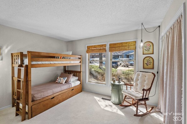 A bunk bed room with a rocking chair, a window with blinds, and a radiator. - Treetop Trailhaven-Direct Access to MTB Trails! (Bella Vista)