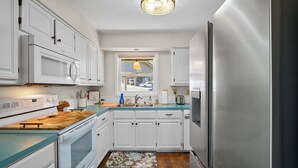 A compact kitchen with white cabinets, a stainless steel refrigerator, and a wooden countertop. - Treetop Trailhaven-Direct Access to MTB Trails! (Bella Vista)