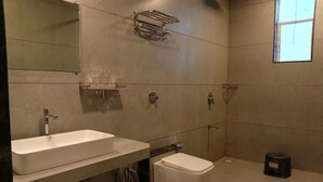 A bathroom with a white sink, a toilet, a mirror, and a window. - Mountain Meadows Resort (Mahabaleshwar)