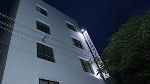 A multi-story building with a prominent sign on the side. - Shankar Guest House (Kolkata)
