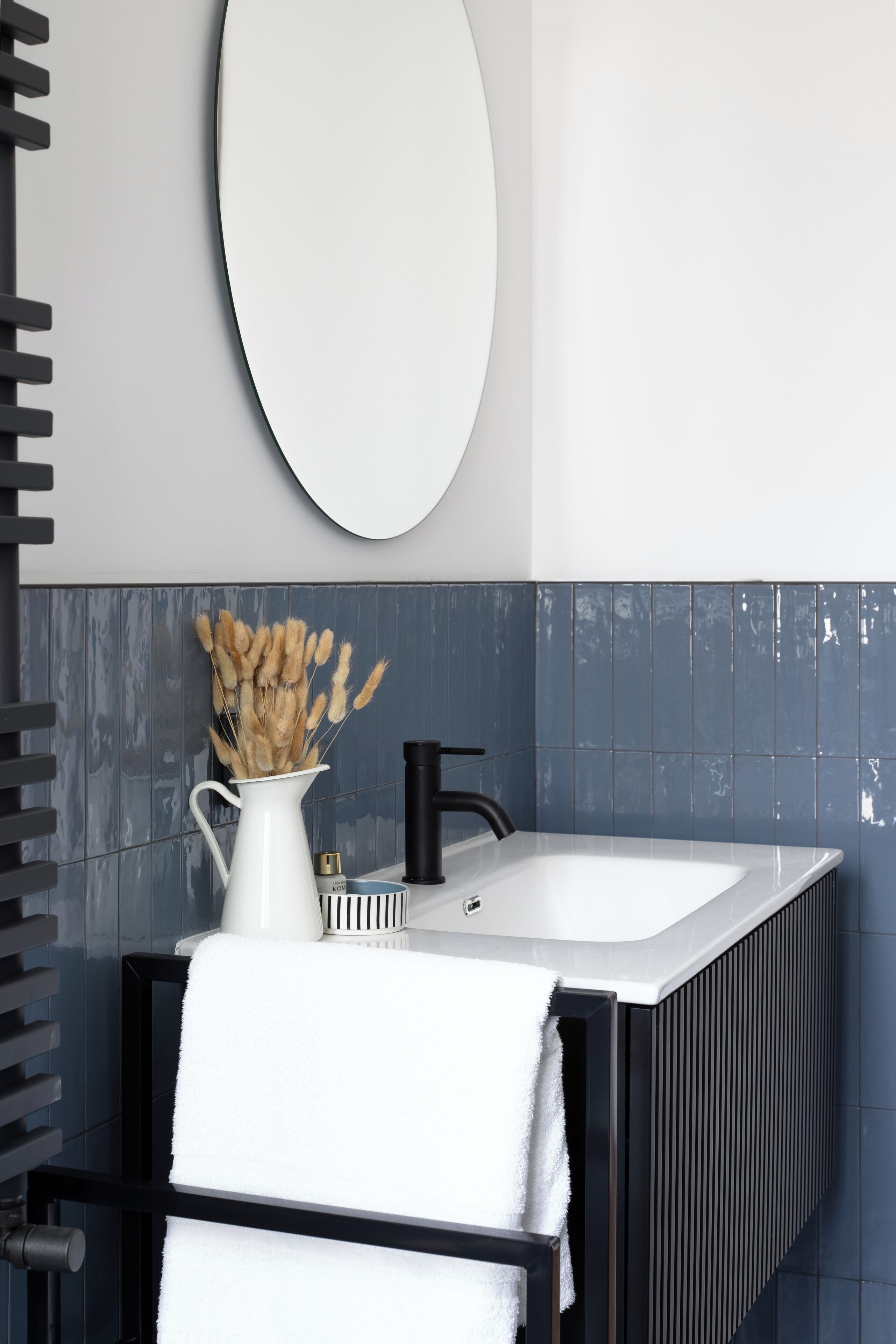 A modern bathroom with a large bathtub, a white sink, and a mirror above the sink.