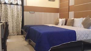 A hotel room with a bed, a desk, and a chair. - Hotel Nala Residency (Tiruvannamalai)