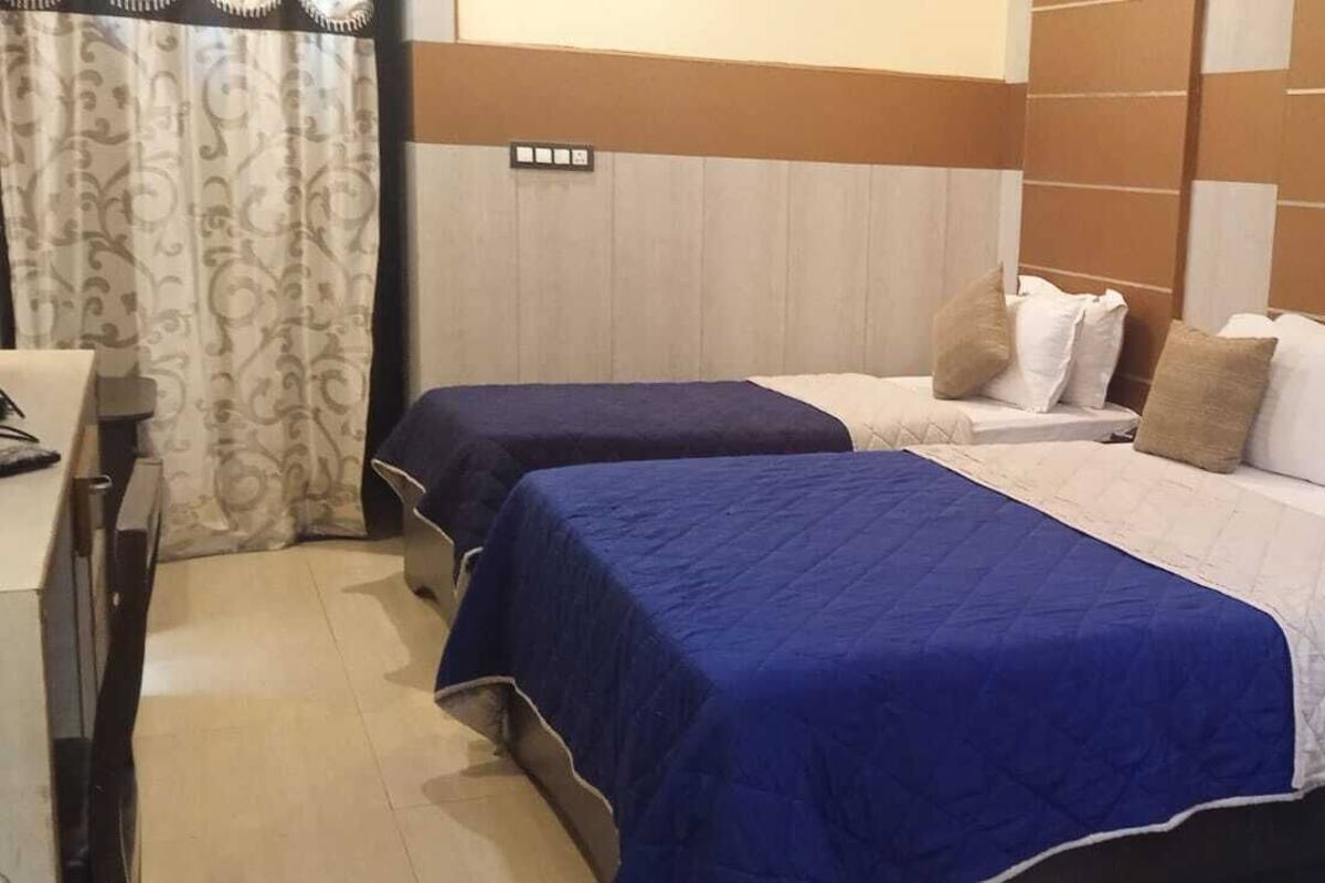 Una habitación de hotel con dos camas, un escritorio y una silla.