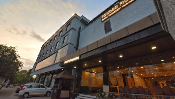 A hotel with a modern facade, a restaurant sign, and a car parked in front. - Foxoso Fiori Hotel (Jaipur)