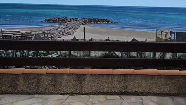 A beach view with a stone patio in the foreground. - VILLA POSEÏDON FRONTIGNAN PLAGE (Frontignan)