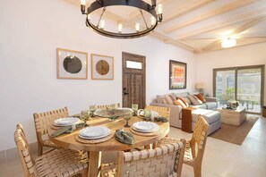 Enjoy meals in style with a round table set for four, accompanied by matching chairs and elegant glassware.