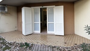 An entrance with a tiled floor, a white door with shutters, and an air conditioning unit on the wall. - Villaggio Tivoli 6-c13 (San Michele al Tagliamento)