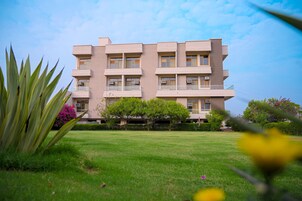 A multi-story building with a flat roof, rectangular windows, and balconies.