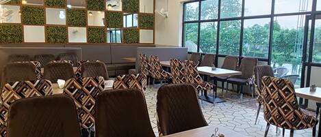 A restaurant with a modern interior, featuring a mix of seating arrangements, including booths and tables.