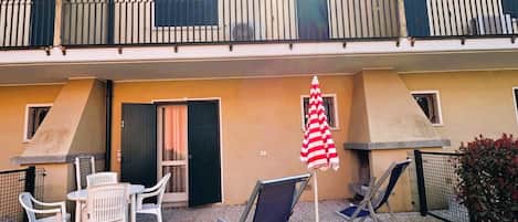 Ein zweistöckiges Gebäude mit Balkon, Außenbereich und einer Flagge.