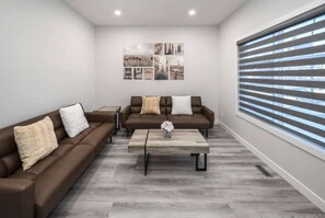 Relax in this stylish living room with two comfortable sofas, a coffee table, and a large window offering a view.