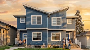 A two-story house with a stone foundation and a blue exterior.