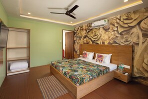 Un dormitorio con cama de madera, ventilador de techo, aire acondicionado de pared y pared con diseño.
