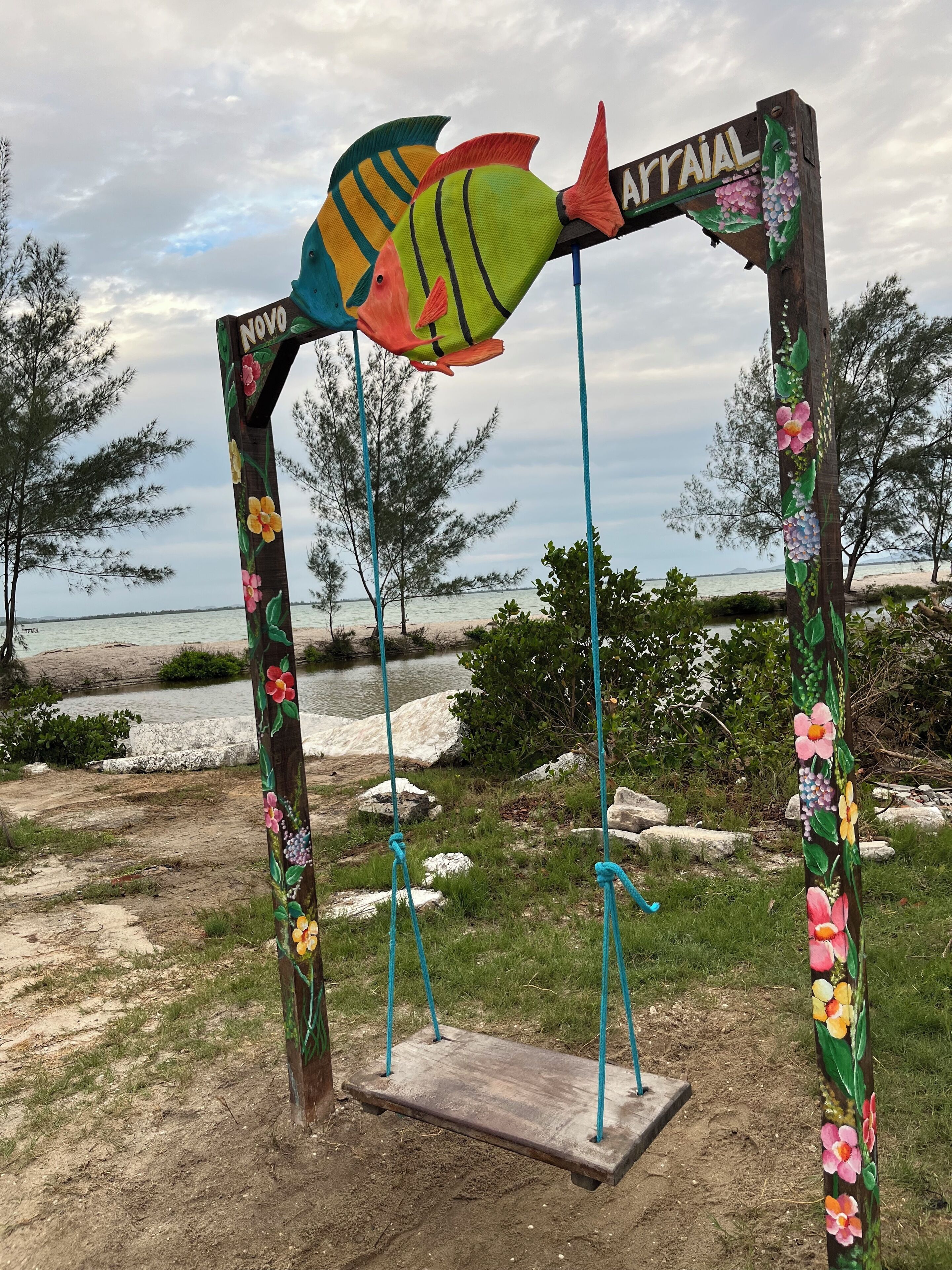 Un columpio de madera con un adorno de pez colorido y un letrero que dice 'Appaial'.