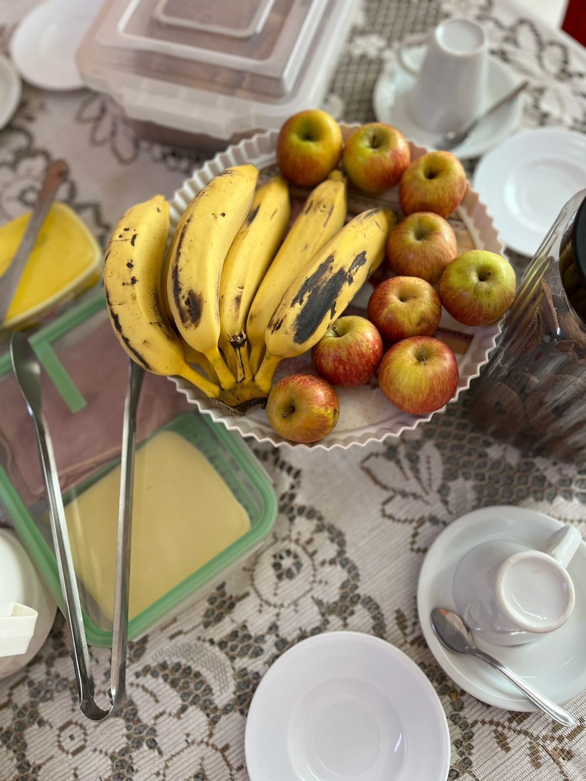 Et bord med et frugtfat, en kaffepotte og diverse tallerkener.