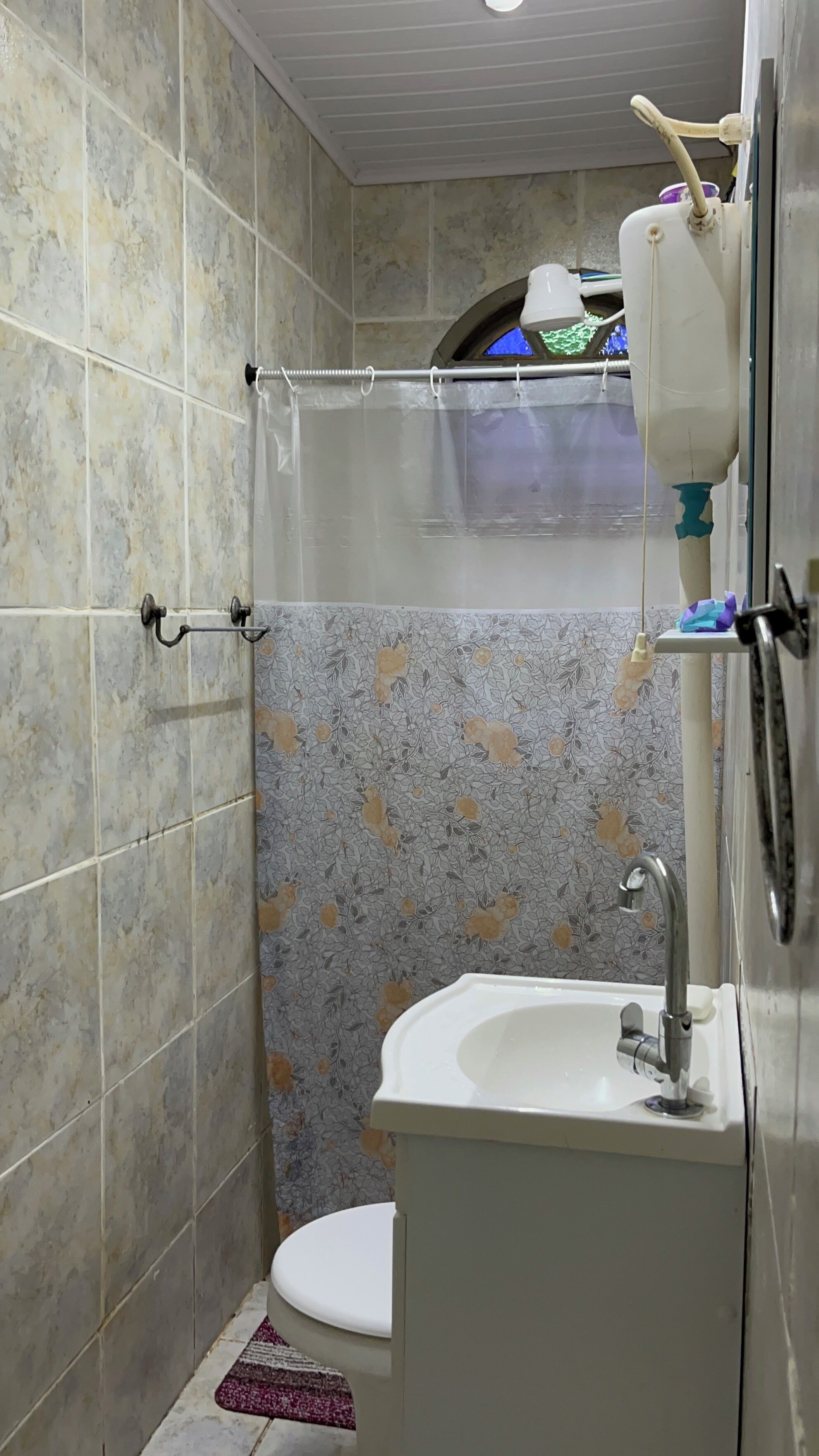 A bathroom with a toilet, sink, and shower curtain.
