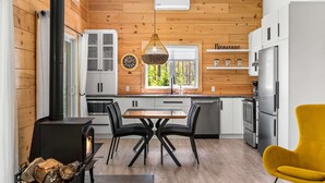 Een moderne keuken met een centraal eiland, houten wanden en een zwart fornuis.