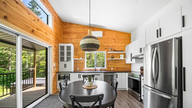 A modern kitchen with a large island, stainless steel appliances, and a view of the outdoors. - Spa, Nature & Riverside Escape | Ecureuil Roux (Trois-Rives)