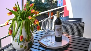 A balcony with a table set for two, featuring a vase of tulips and a bottle of wine. - Ruga Vacation Rental 7 in Ascona (Ascona)