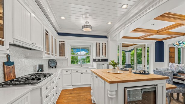 A spacious kitchen with white cabinetry, a wooden countertop, and a built-in oven. - Castle Azul: Luxury canal front w/pool, hot tub, putting green, and ping pong (Anna Maria)