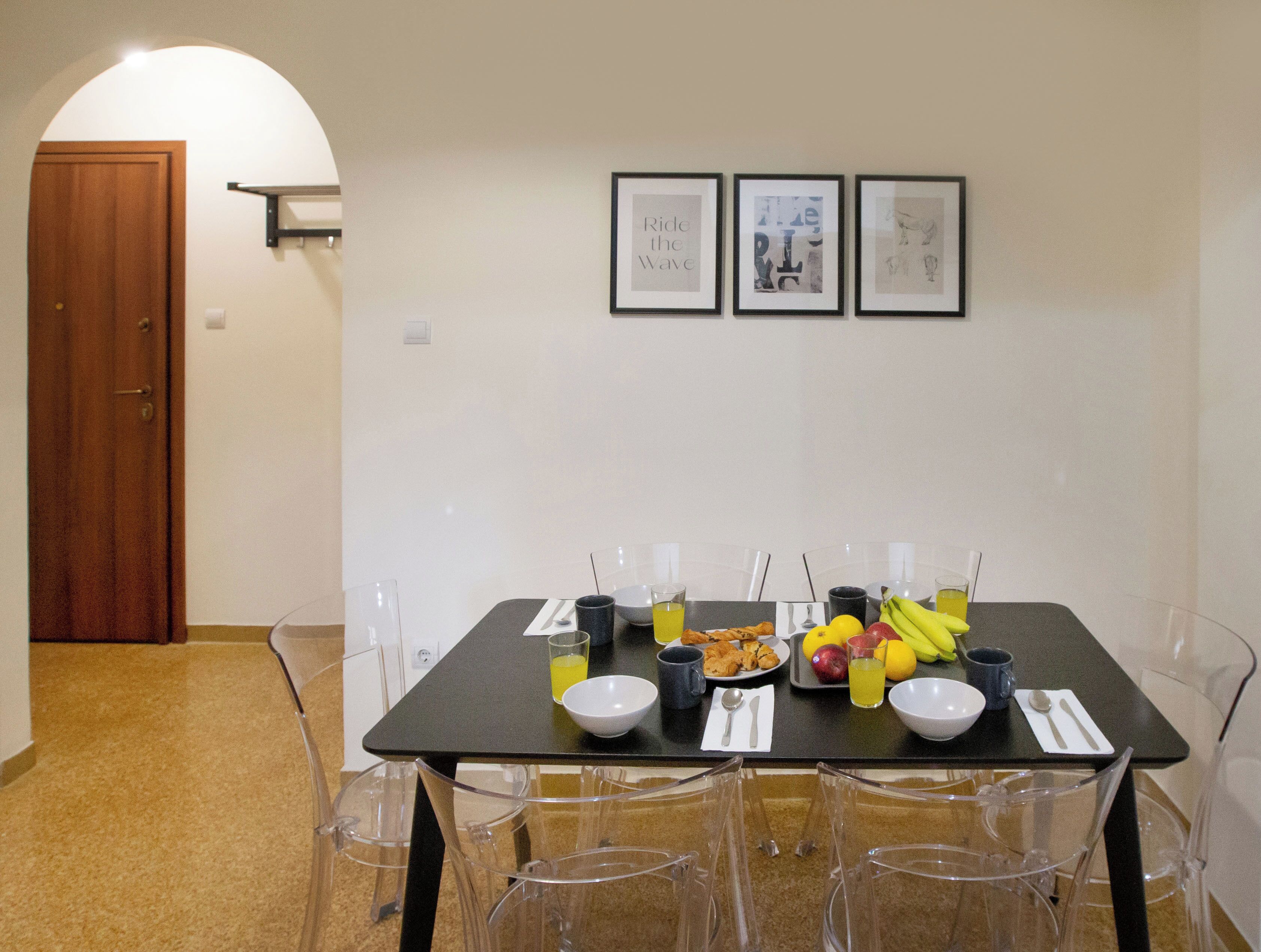 Un coin repas avec une table dressée pour deux personnes, agrémenté de beaux verres, d’assiettes et d’une variété de fruits et de boissons.