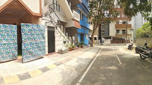 A residential building with a tiled entrance, a staircase, and a parked motorcycle. - Soloscape budget friendly backpackers hostel (Bengaluru)