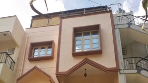 A multi-story building with a flat facade, balconies, and a patterned gate. - Soloscape budget friendly backpackers hostel (Bengaluru)