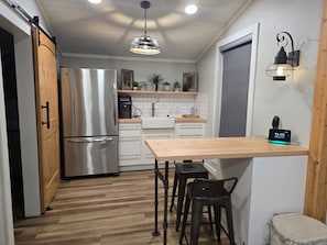 Enjoy cooking in this fully equipped kitchen with a refrigerator, coffee machine, and dining area.