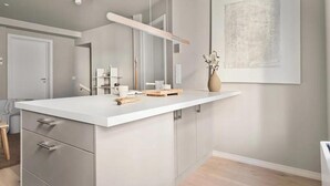 Un bany modern amb un mirall gran, taulell blanc i decoració minimalista.
