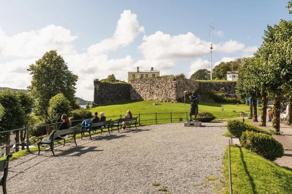 A park with stone walls, benches, and a statue.