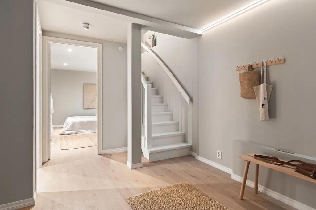 A hallway with a staircase leading to a bedroom.
