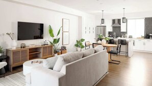 Un salon moderne avec un canapé, un téléviseur et un coin repas.