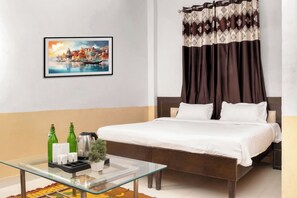 Relax in a stylish room with a large bed, framed cityscape, and a cozy coffee table.
