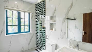A modern bathroom with a toilet, sink, and mirror.