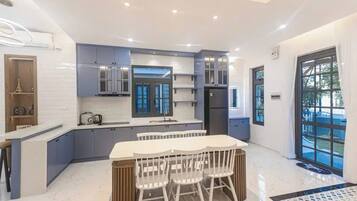 A modern kitchen with a central island, built-in cabinets, and a large window.