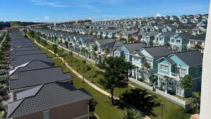 Zona residencial con hileras de casas de techo a dos aguas y vallas blancas.