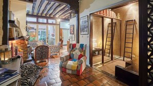A cozy living room with a fireplace, zebra-patterned sofa, and a colorful armchair. - Superbe Apartment Le Marais/Place des Vosges (Paris)