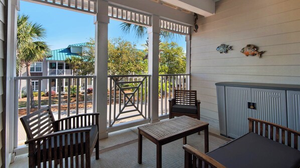 A covered outdoor area with a wooden bench, a table, and a cabinet.
