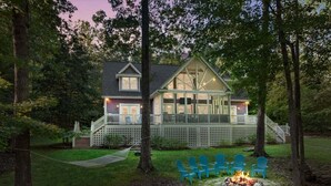 A house with a deck, a fire pit, and blue chairs in the yard. - Water You Wating For? | Waterfront Fun & Relaxation (Boydton)
