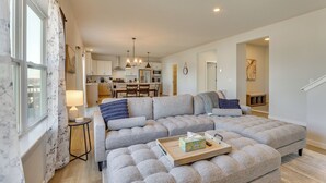 A modern living room with a large sectional sofa, a small side table, and a wooden tray with tissues. - 13 Mi to University of Wisconsin: Suburban Home (Oregon)