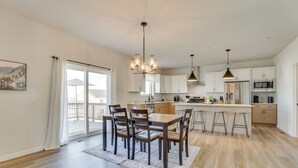 A spacious kitchen with a dining area, featuring a large island with bar stools, modern appliances, and a chandelier. - 13 Mi to University of Wisconsin: Suburban Home (Oregon)