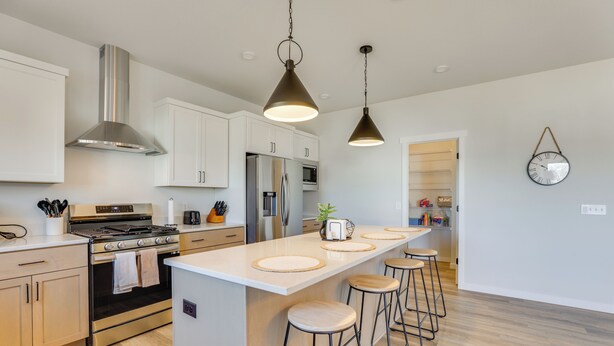 A modern kitchen with stainless steel appliances, wooden bar stools, and pendant lighting. - 13 Mi to University of Wisconsin: Suburban Home (Oregon)