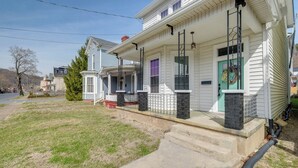 A two-story house with a front porch, a green door, and a stone pillar. - Updated & Charming! Home Near Douthat State Park (Clifton Forge)