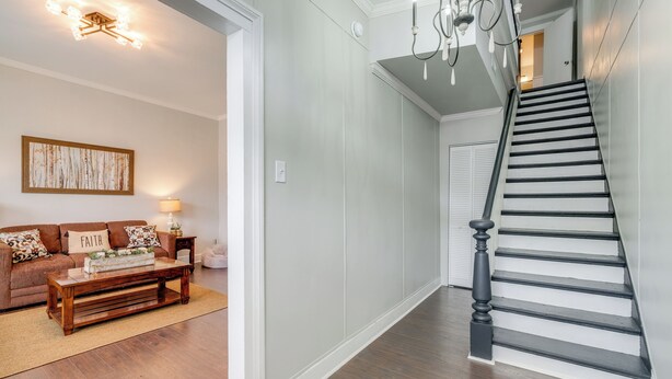 A staircase with a black balustrade leading to a landing. - Updated & Charming! Home Near Douthat State Park (Clifton Forge)