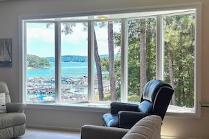 Habitación con un ventanal que ofrece vistas a un puerto deportivo y árboles.