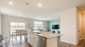 A modern kitchen with a central island, built-in appliances, and a dining area with a view. - 6 Mi to Bethany Beach: Family Home w/ Pool Access! (Millville)