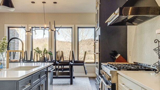 A modern kitchen with a large island, built-in appliances, and large windows offering a view of the outdoors. - Lakefront Gem: Dock & Hot Tub in Jacksboro (Jacksboro)