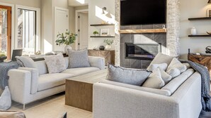 A modern living room with a large TV, built-in fireplace, and a cozy seating area. - Lakefront Gem: Dock & Hot Tub in Jacksboro (Jacksboro)