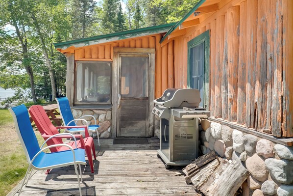 A wooden cabin with a porch, outdoor seating, and a grill. - South Twin Lake Cabin w/ Seasonal Dock & Slip! (Conover)